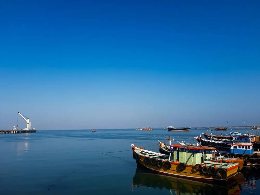 Fishing boats at anchor near a port crane