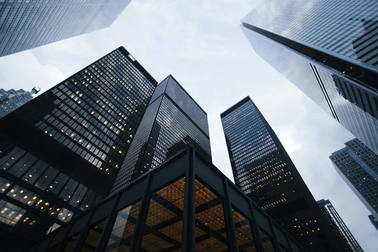 Glass corporate office towers seen from street level against the sky