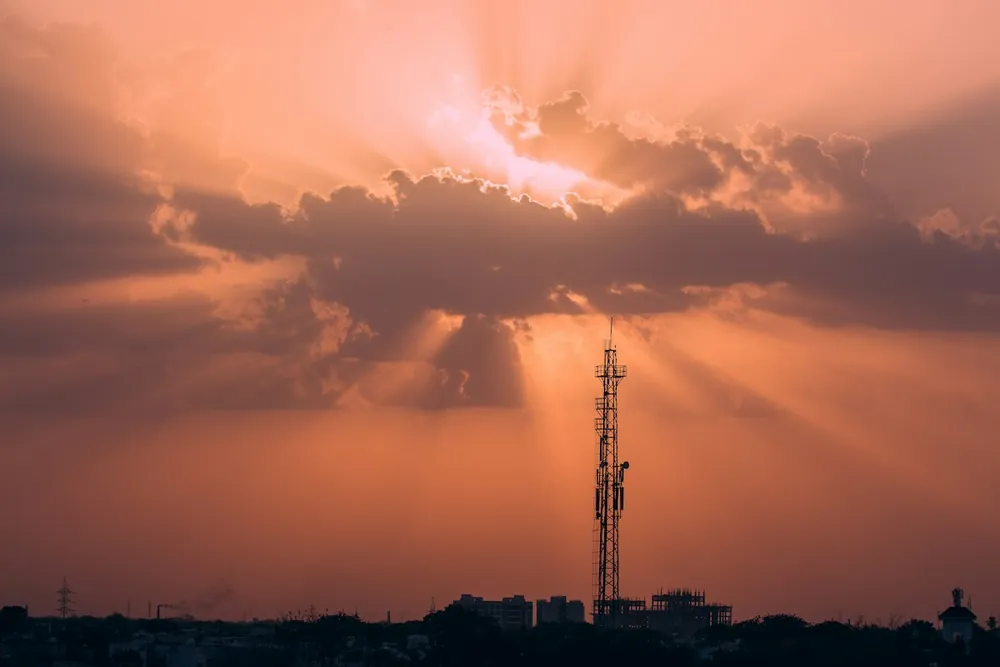 A communications tower silhouetted against a sunset sky